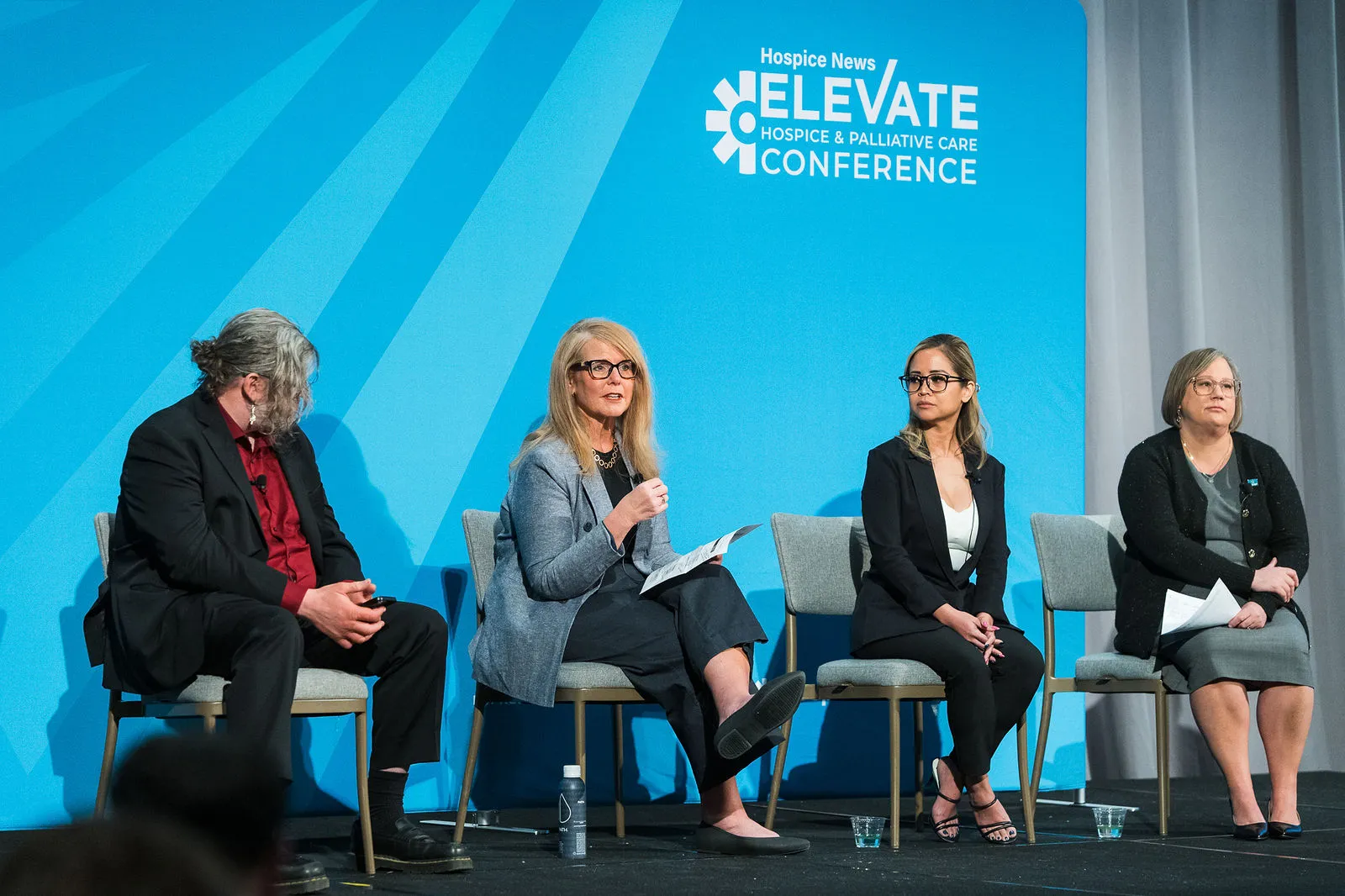 Monica Cutia en un panel de cuatro personas en el escenario de la conferencia ELEVATE de Hospice News