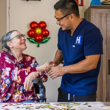 A HealthView nurse holding hands with a smiling patient
