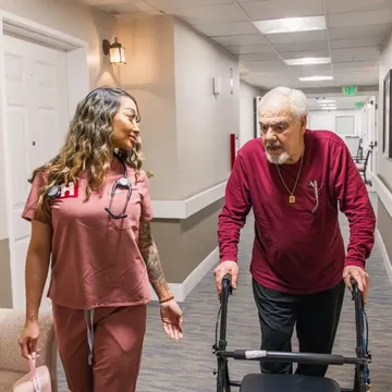 A HealthView nurse walking beside a patient using a walker