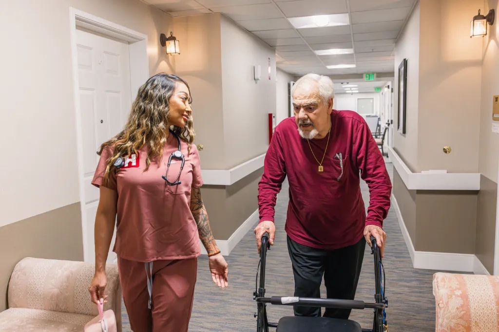 Una enfermera de HealthView camina junto a un paciente que usa andadera