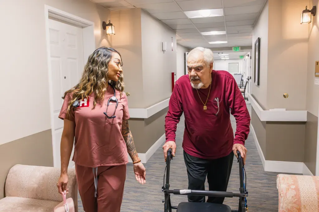 Una enfermera de HealthView camina junto a un paciente que usa andadera